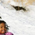 Two girls snow sledding